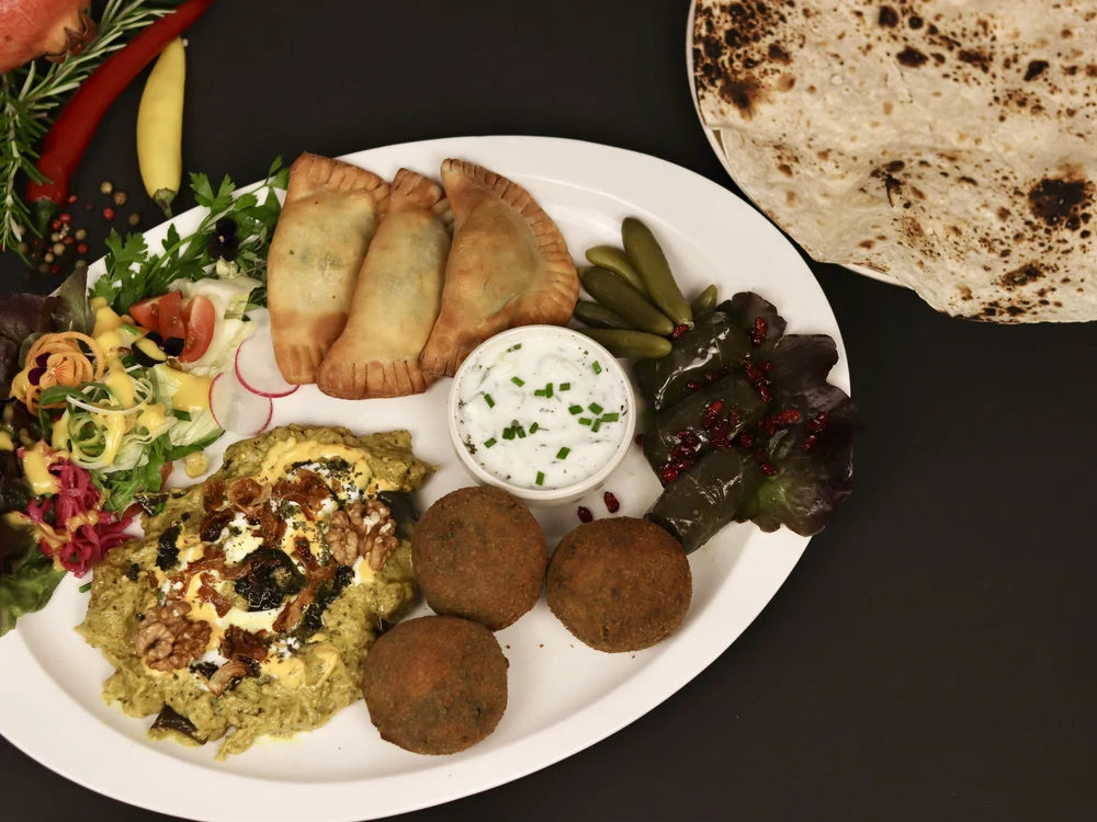 Persisches Fingerfood: gefüllte Teigtaschen, Kräuterbällchen, Dips und Fladenbrot